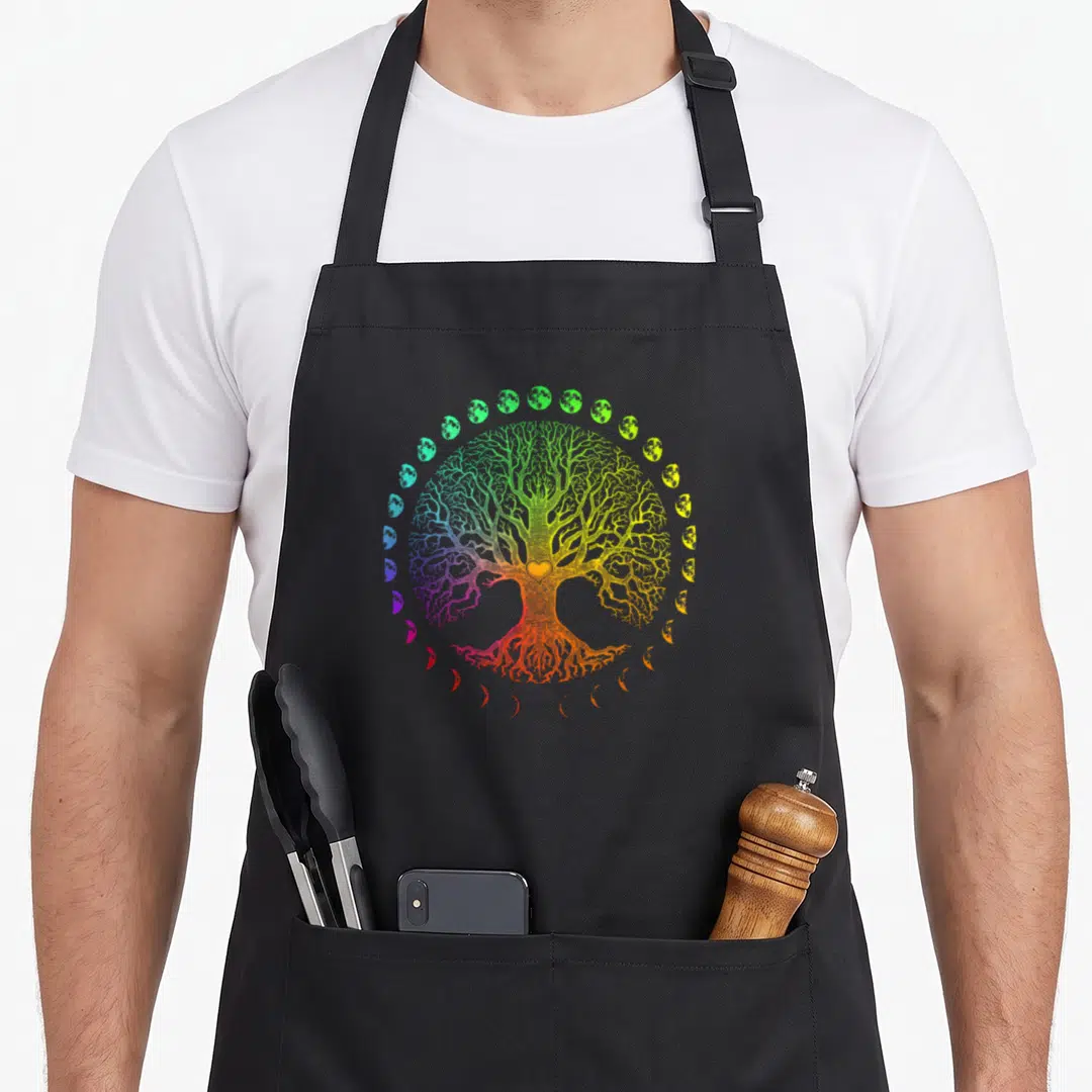 Cute phase tree apron - Rainbow tree of life line art surrounded by moon phases on black fabric — shown on a black cotton canvas apron against a white background
