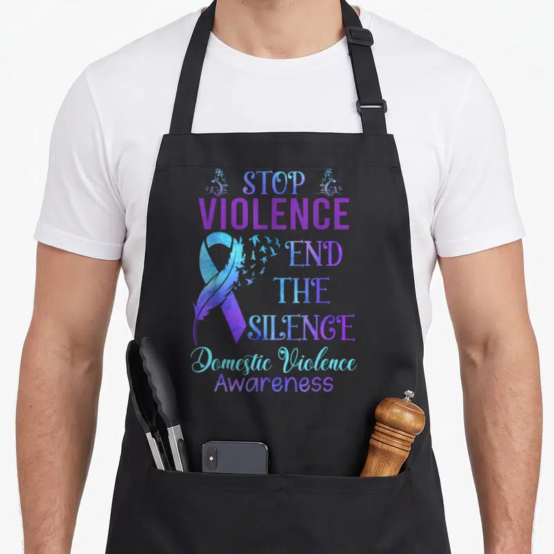 Family domestic aprons - Purple blue awareness ribbon with flying birds and text Stop Violence End The Silence — shown on a black cotton canvas apron against a white background