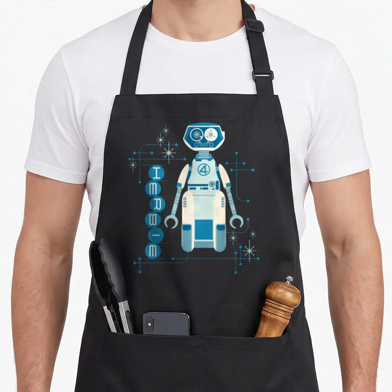 Studio h-e-b apron - Retro blue and white robot standing next to vertical HERBIE text in circles with circuit lines — shown on a black cotton canvas apron against a white background