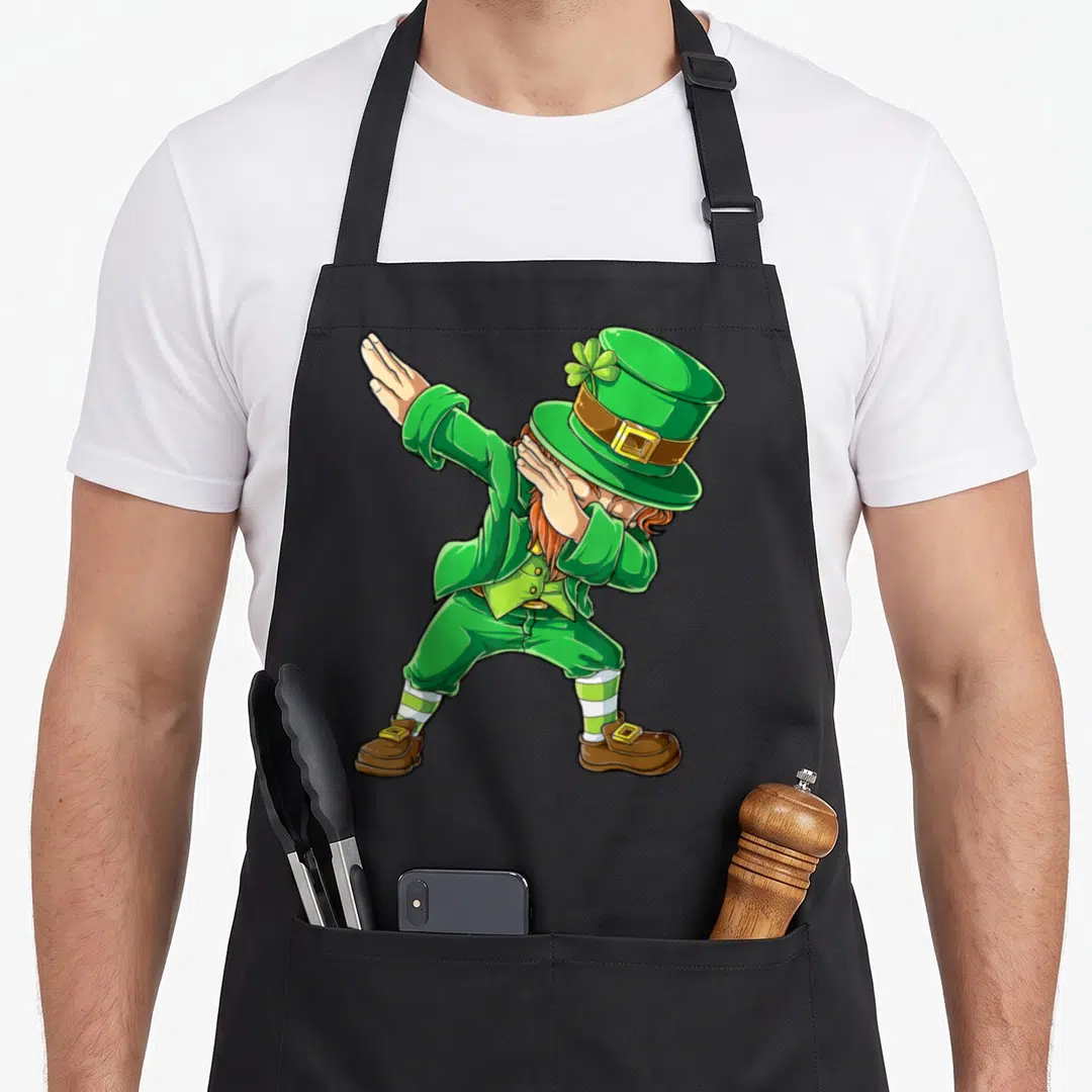 Dabbing st patrick day aprons - Cartoon leprechaun in green dabbing pose with hand covering face and top hat — shown on a black cotton canvas apron against a white background