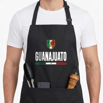 Guanajuato mexico apron - GUANAJUATO text with shield and tricolor flag bars in white green red — shown on a black cotton canvas apron against a white background