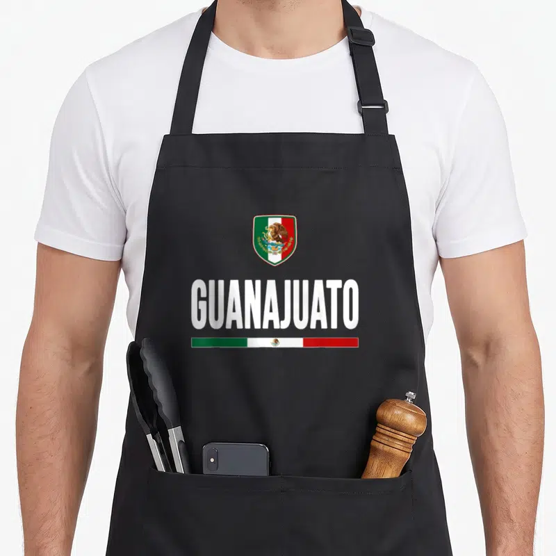 Guanajuato mexico apron - GUANAJUATO text with shield and tricolor flag bars in white green red — shown on a black cotton canvas apron against a white background