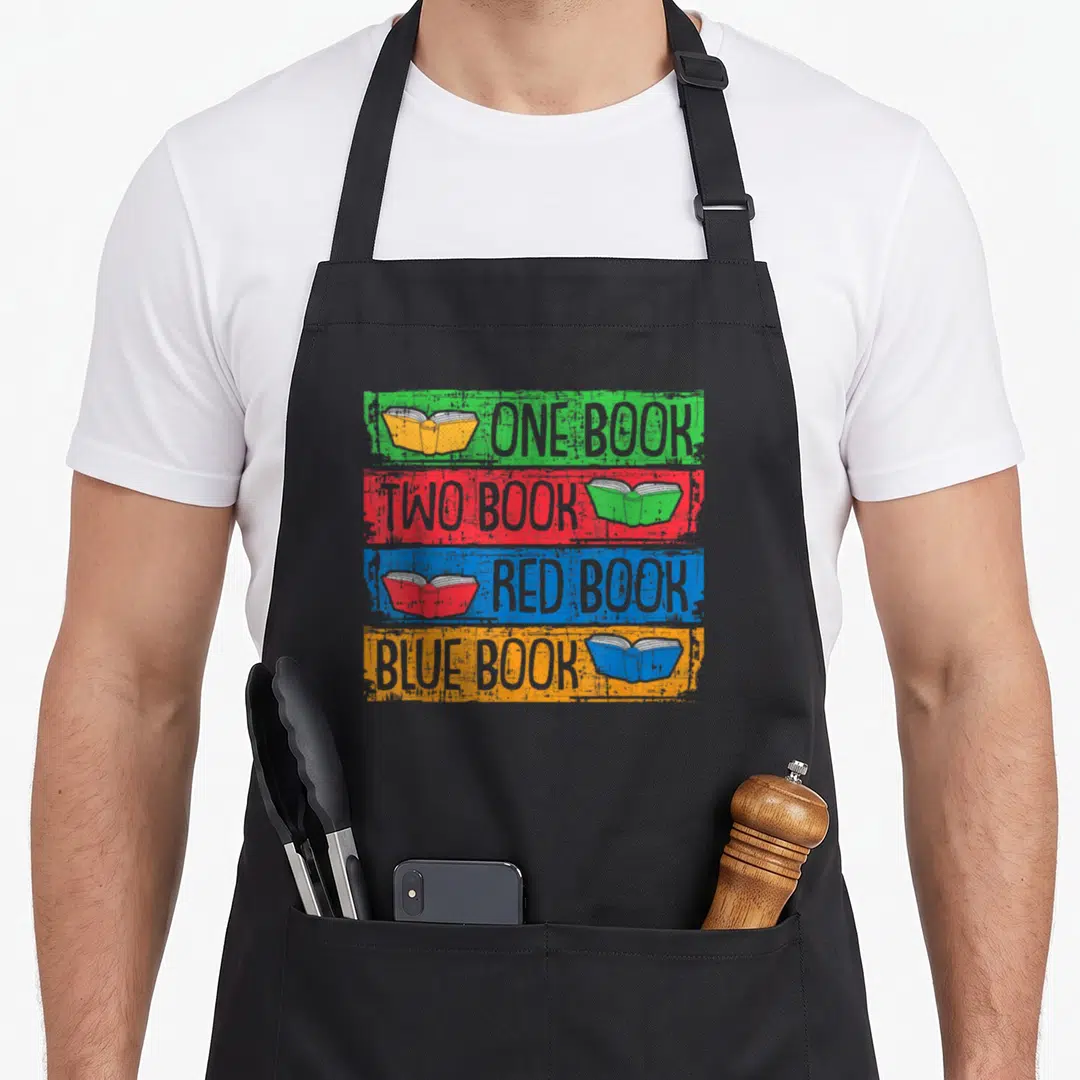 Worm nerd apron - Four stacked colored bars with open book icons and text reading one book two book red book blue book — shown on a black cotton canvas apron against a white background