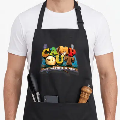 Getting camp chef apron - CAMP OUT text with s'more letters, two owls, blue wood sign, GETTING S'MORE OF JESUS tagline — shown on a black cotton canvas apron against a white background