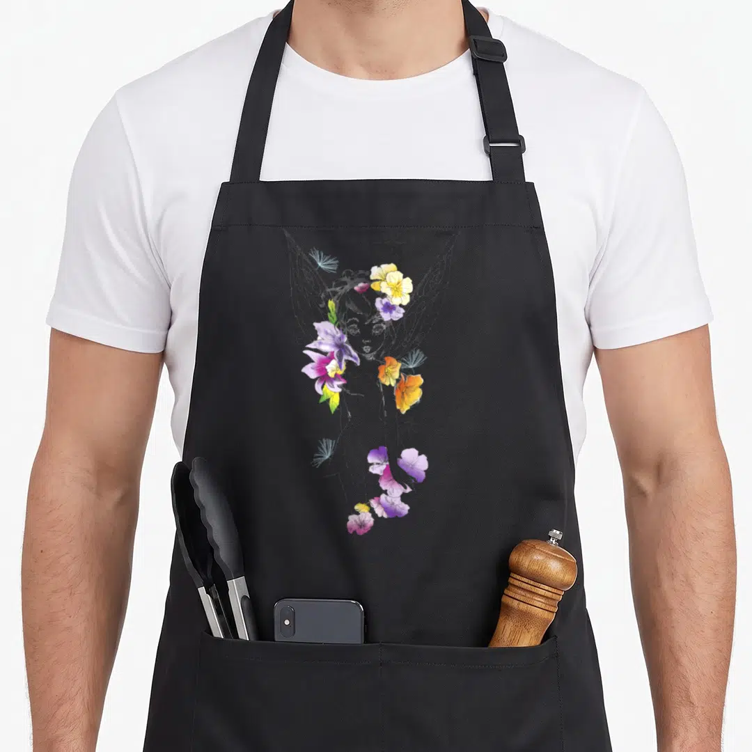 Peter floral apron - Grey fairy line art with scattered purple yellow pink flowers and stars — shown on a black cotton canvas apron against a white background