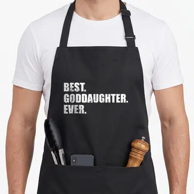 Goddaughter daughter of god apron - Stacked white text reading BEST GODDAUGHTER EVER on gray background — shown on a black cotton canvas apron against a white background