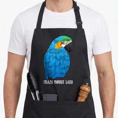 Blue crazy parrot lady apron - Cartoon blue macaw parrot above white text CRAZY PARROT LADY — shown on a black cotton canvas apron against a white background