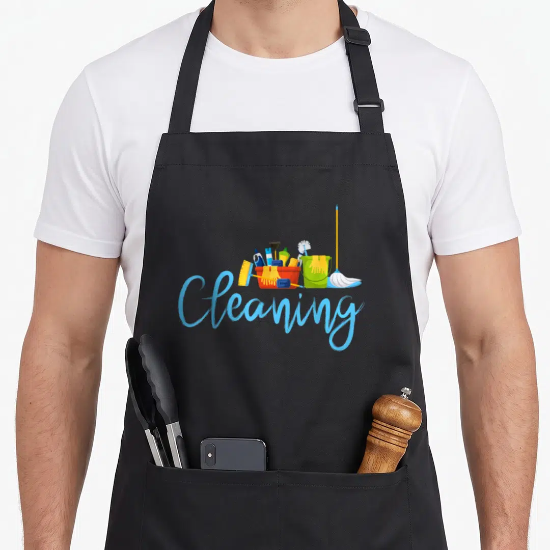 Funny cleaning housekeeper apron - Cartoon red and green buckets filled with brushes, yellow gloves, soap, and a mop — shown on a black cotton canvas apron against a white background