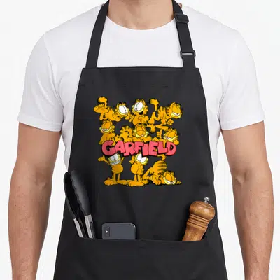 Pose general apron - Nine orange cats surrounding red GARFIELD text in cartoon style with black outlines — shown on a black cotton canvas apron against a white background
