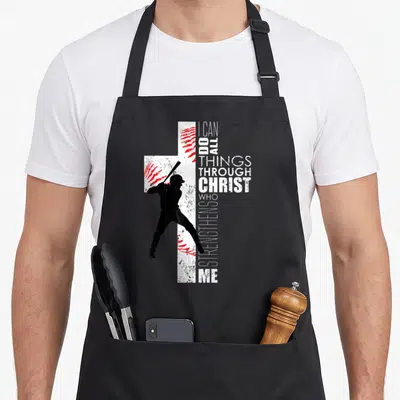 Christian baseball cross apron - Distressed white cross with red stitching and black batter silhouette beside vertical — shown on a black cotton canvas apron against a white background
