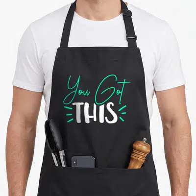 Funny teacher test kitchen apron - You Got THIS text design in turquoise script and white block font with three accent — shown on a black cotton canvas apron against a white background