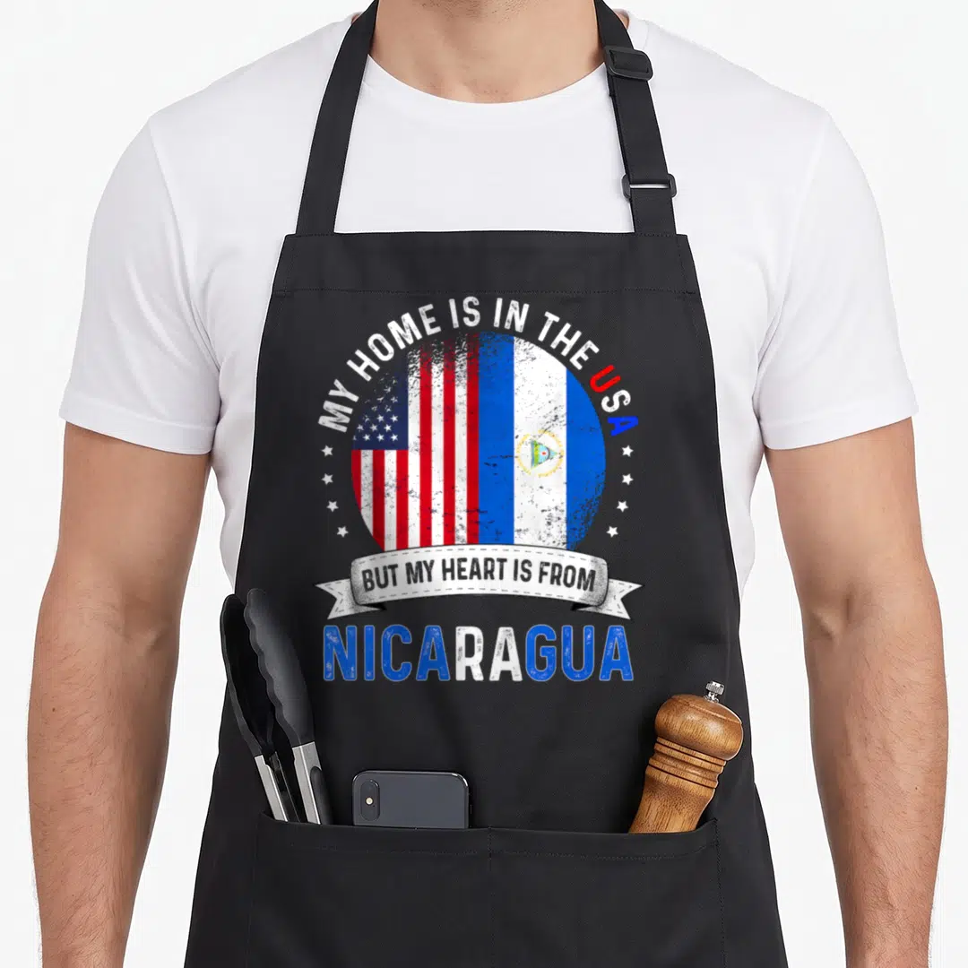 Nicaraguan patriot american flag apron - Distressed circular graphic with USA and Nicaragua flags flanked by small — shown on a black cotton canvas apron against a white background