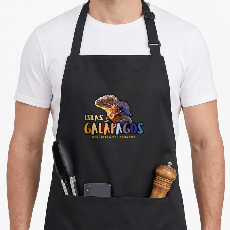 Islas bucket apron - Cartoon iguana above colorful ISLAS GALÁPAGOS REPÚBLICA DEL ECUADOR text in orange blue yellow — shown on a black cotton canvas apron against a white background