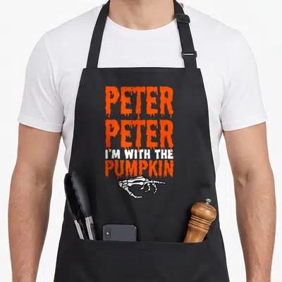 Costume halloween kitchen aprons - Orange dripping text Peter I'm With The Pumpkin above white skeleton hand — shown on a black cotton canvas apron against a white background