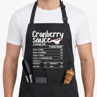 Sauce nutrition fact thanksgiving apron - White nutrition label text and red sauce gravy boat on black apron — shown on a black cotton canvas apron against a white background