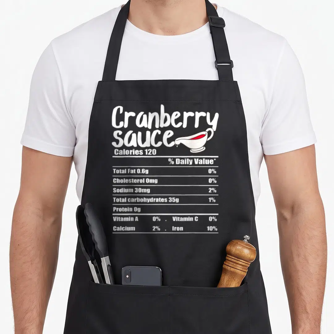 Sauce nutrition fact thanksgiving apron - White nutrition label text and red sauce gravy boat on black apron — shown on a black cotton canvas apron against a white background