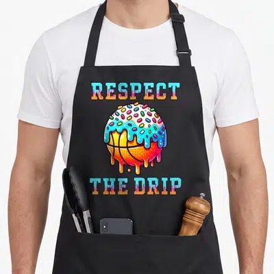 Respect basketball drip apron - Cartoon basketball with blue frosting and sprinkles flanked by RESPECT THE DRIP text — shown on a black cotton canvas apron against a white background