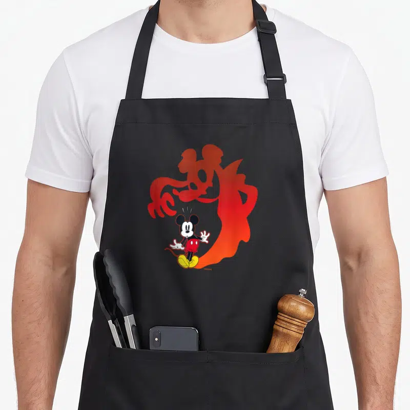 Shadow halloween apron - Mickey Mouse cartoon standing in front of a large red gradient vampire silhouette — shown on a black cotton canvas apron against a white background