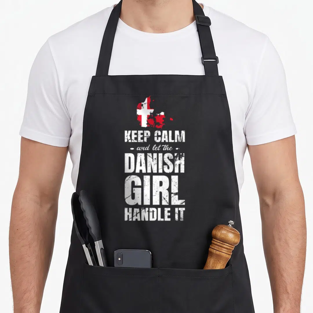 Danish denmark apron - Red and white map of Denmark above distressed white text on dark background — shown on a black cotton canvas apron against a white background