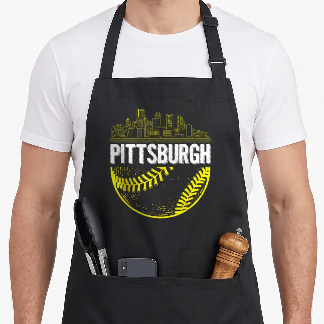 Pittsburgh skyline baseball apron - Yellow skyline above white PITTSBURGH text over bottom half of yellow baseball — shown on a black cotton canvas apron against a white background