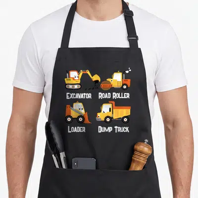 Toddler dump truck apron - Four cartoon construction vehicles labeled Excavator Road Roller Loader Dump Truck in yellow — shown on a black cotton canvas apron against a white background