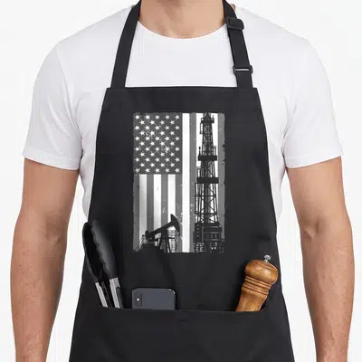 Oil rig girl apron - Distressed USA flag with grey oil rig and pumpjack silhouette in white and grey — shown on a black cotton canvas apron against a white background