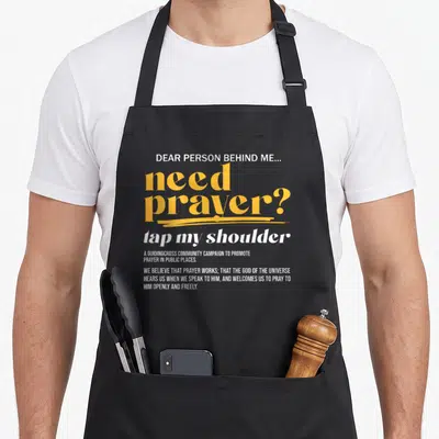 Tap christian apron - Stacked white and yellow typography reading need prayer tap my shoulder and guidingcross campaign — shown on a black cotton canvas apron against a white background