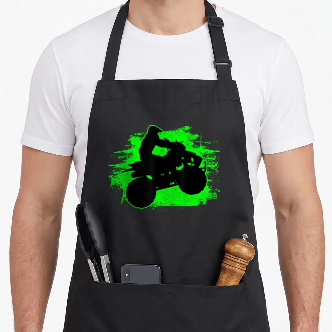 Quad atv bike apron - Black ATV rider silhouette on neon green paint splatter graphic — shown on a black cotton canvas apron against a white background