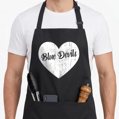Blue devil's apron - Distressed white heart with grey Blue Devils text — shown on a black cotton canvas apron against a white background