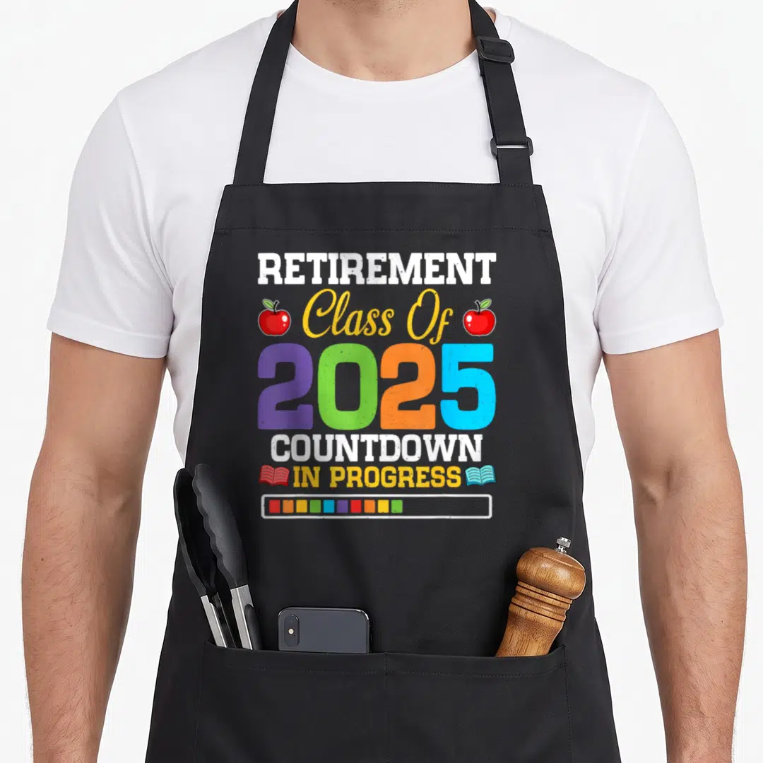Class countdown teacher apron - Retirement Class Of 2025 Countdown In Progress text with colorful apples and books — shown on a black cotton canvas apron against a white background