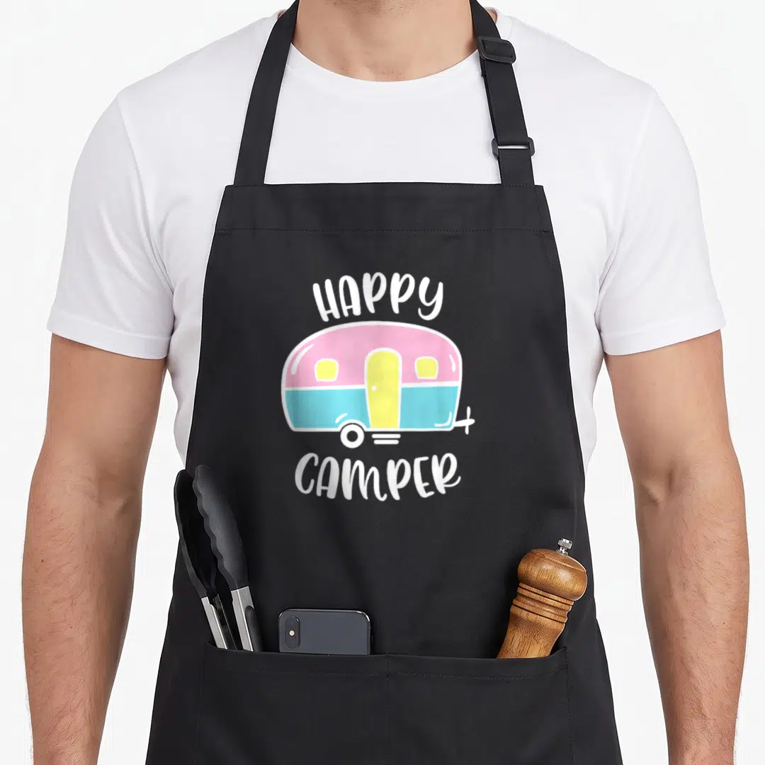 Decor trailer apron - Pink blue and yellow cartoon camper illustration with white HAPPY CAMPER text — shown on a black cotton canvas apron against a white background