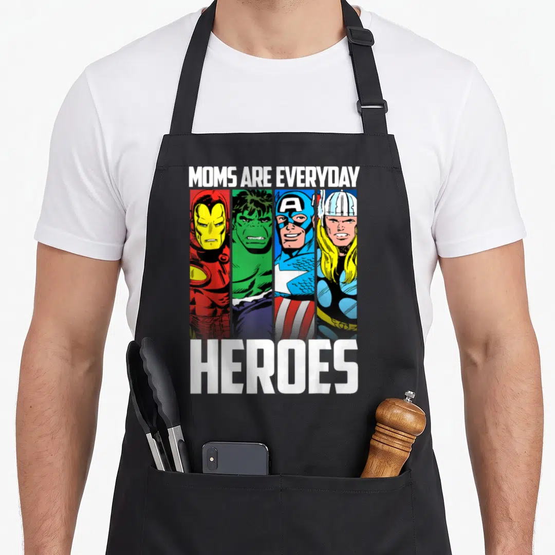 Everyday mother's day aprons - MOMS ARE EVERYDAY HEROES text above four vertical cartoon superhero portraits in red — shown on a black cotton canvas apron against a white background