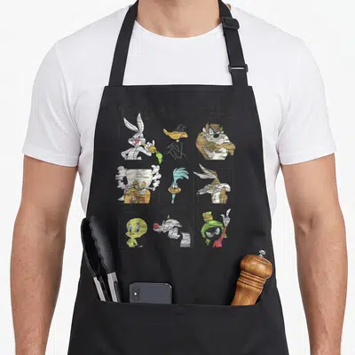Today character aprons - Distressed grid of Looney Tunes characters labeled Clever, Sarcastic, Irritable, Hot Headed — shown on a black cotton canvas apron against a white background