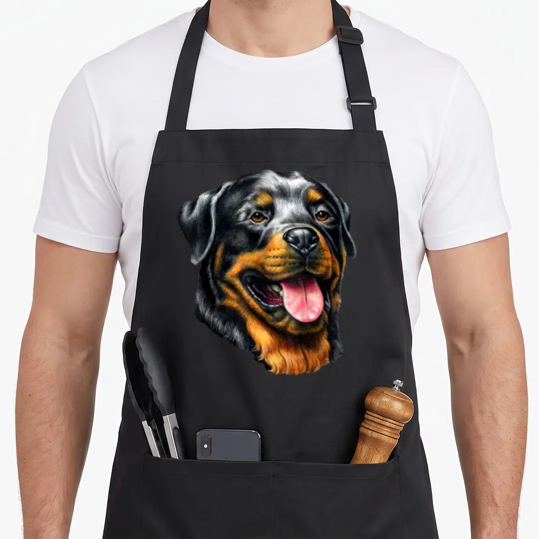 Portrait dog face apron - Realistic Rottweiler head portrait in black tan and pink watercolor style — shown on a black cotton canvas apron against a white background