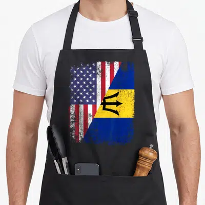 Barbado american flag apron - Two flags merged diagonally with distressed texture showing stars stripes and trident — shown on a black cotton canvas apron against a white background