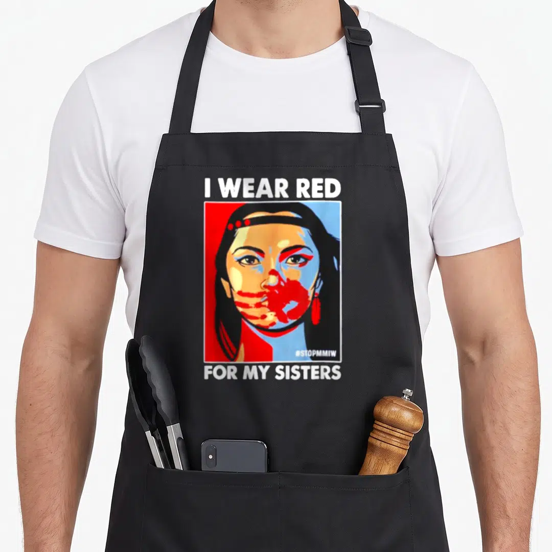 Sister native american apron - Pop art portrait of woman with I WEAR RED text and red hand covering mouth — shown on a black cotton canvas apron against a white background