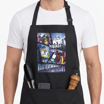 Cut transformer apron - Four robots in grid with purple Decepticon logo and bottom text banner — shown on a black cotton canvas apron against a white background