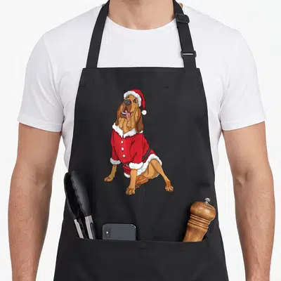 Bloodhound christmas santa apron - Cartoon bloodhound sitting in a red and white Santa suit — shown on a black cotton canvas apron against a white background