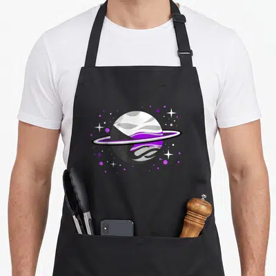 Demisexual pride apron - Purple grey and white planet with rings surrounded by stars and dots — shown on a black cotton canvas apron against a white background