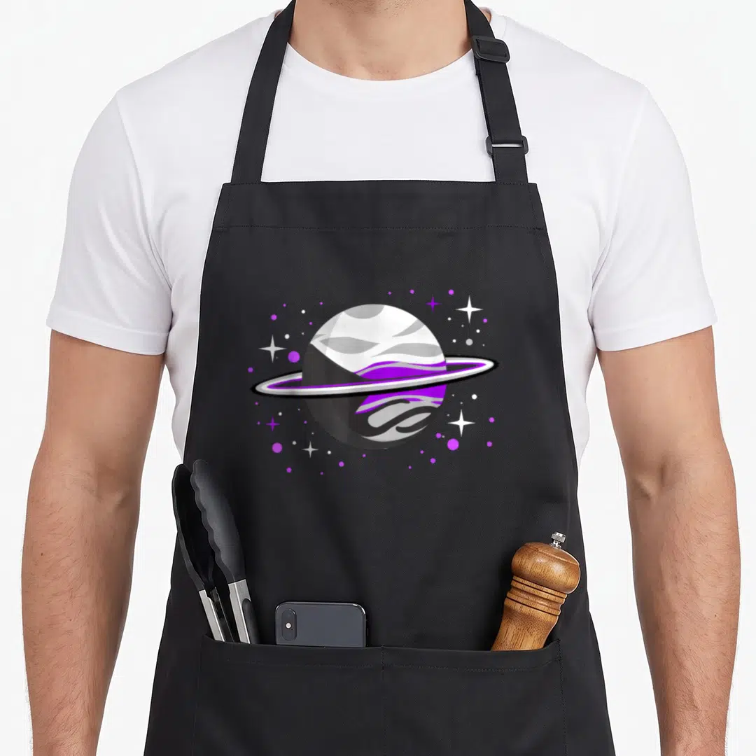 Demisexual pride apron - Purple grey and white planet with rings surrounded by stars and dots — shown on a black cotton canvas apron against a white background