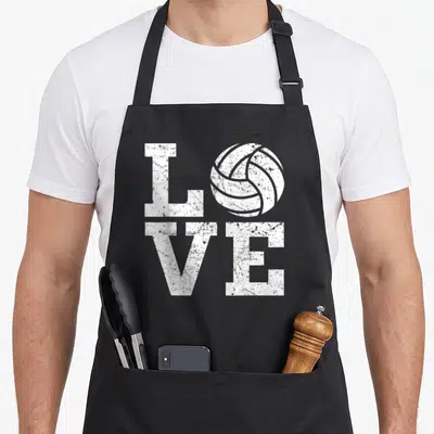 Sport volleyball apron - White LOVE text with volleyball replacing O in distressed two-row block font — shown on a black cotton canvas apron against a white background