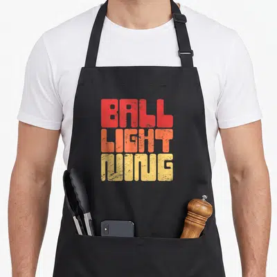 Ball elmo apron - Stacked red orange yellow distressed text reading BALL LIGHT NING — shown on a black cotton canvas apron against a white background