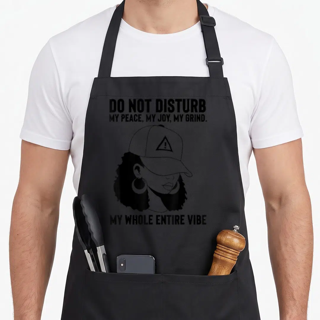 Disturb pride apron - Woman in line art with warning cap and Do Not Disturb text — shown on a black cotton canvas apron against a white background
