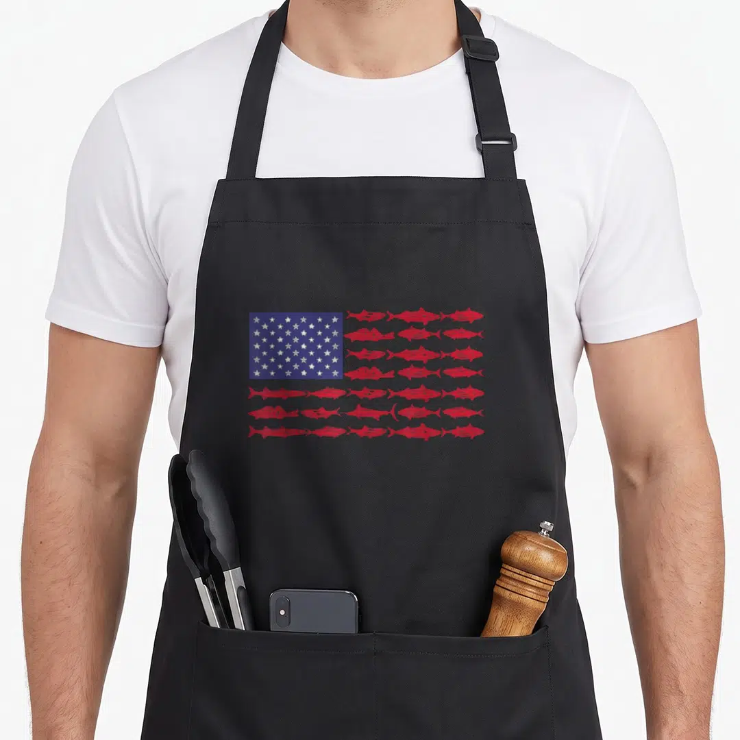 Abs001 american flag apron - US flag design with red fish replacing horizontal stripes next to white stars on blue field — shown on a black cotton canvas apron against a white background