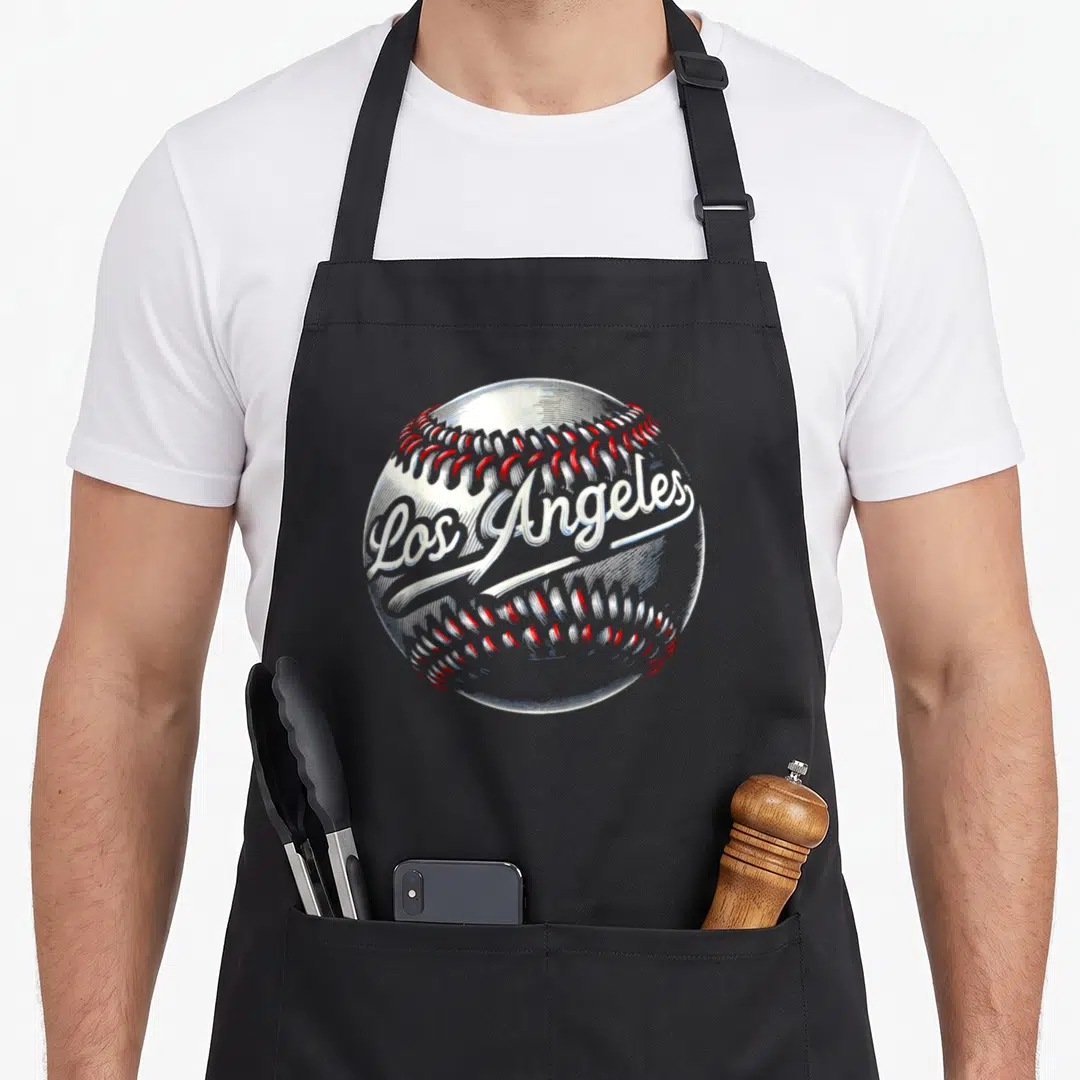 Los angele baseball apron - Realistic white baseball with red stitching and Los Angeles script text — shown on a black cotton canvas apron against a white background