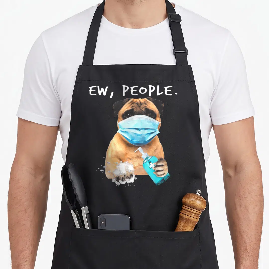 Pug dog face apron - Tan pug in blue mask holding soap bottle with bubbles and text EW PEOPLE — shown on a black cotton canvas apron against a white background