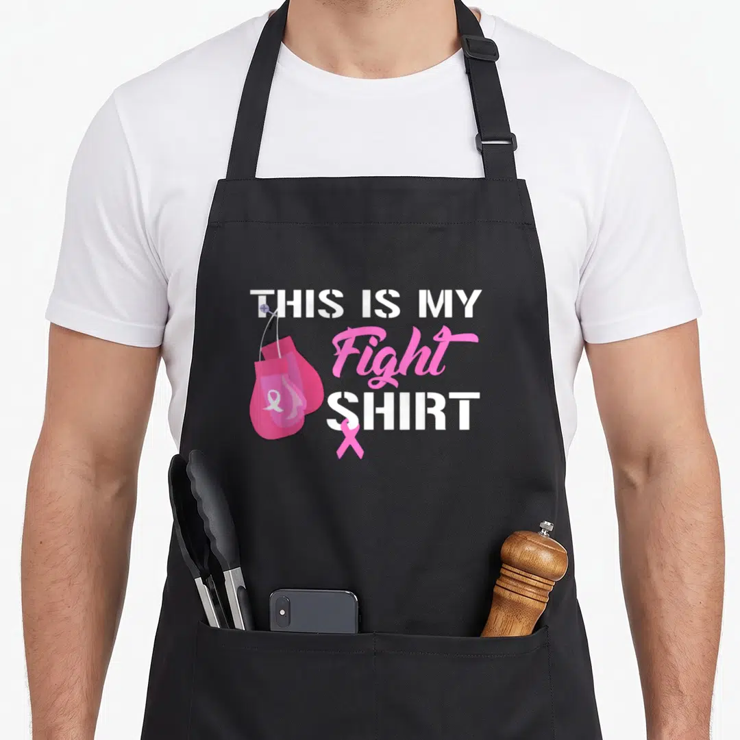 Fight breast cancer awareness for women apron - Pink boxing gloves hanging next to stacked white and pink text — shown on a black cotton canvas apron against a white background