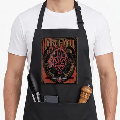 Maul fear apron - Darth Maul face in circle with Fear Death Destruction text and horizontal lightsaber — shown on a black cotton canvas apron against a white background
