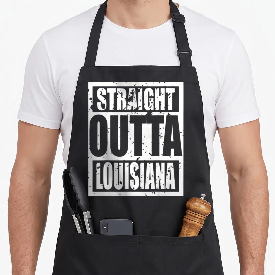 Straight louisiana apron - Stacked STRAIGHT OUTTA LOUISIANA text in white and grey with distressed texture on black — shown on a black cotton canvas apron against a white background