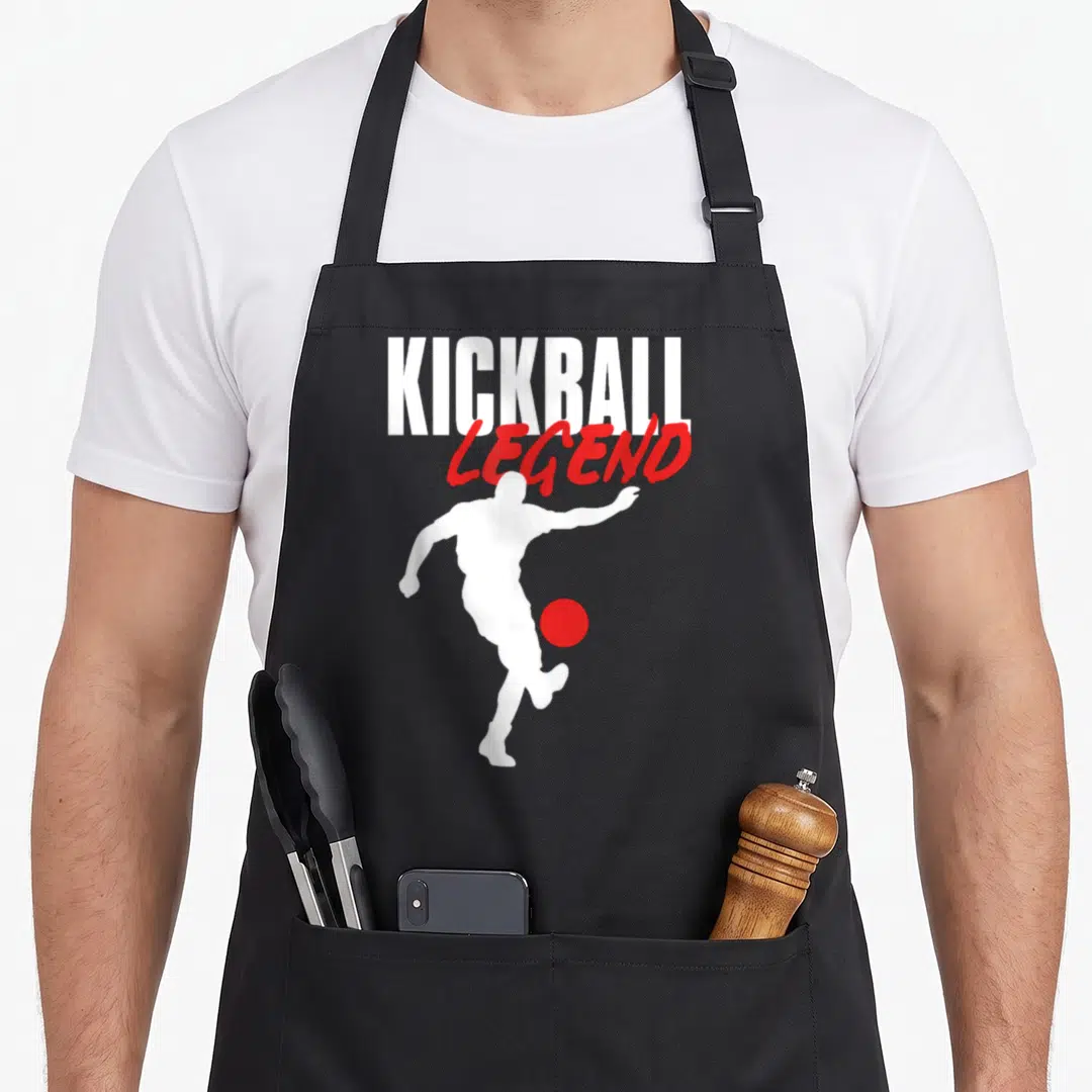 Kickballer kickball apron - White KICKBALL and red LEGEND text above white player silhouette kicking red ball — shown on a black cotton canvas apron against a white background